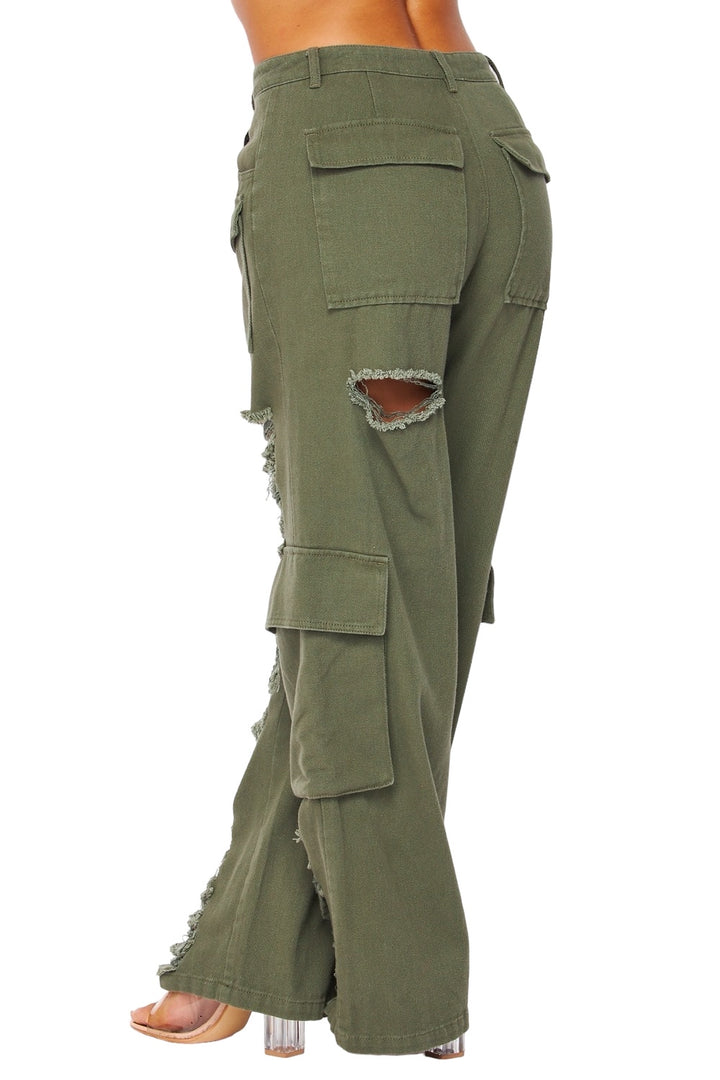 a woman wearing green pants with holes in the side