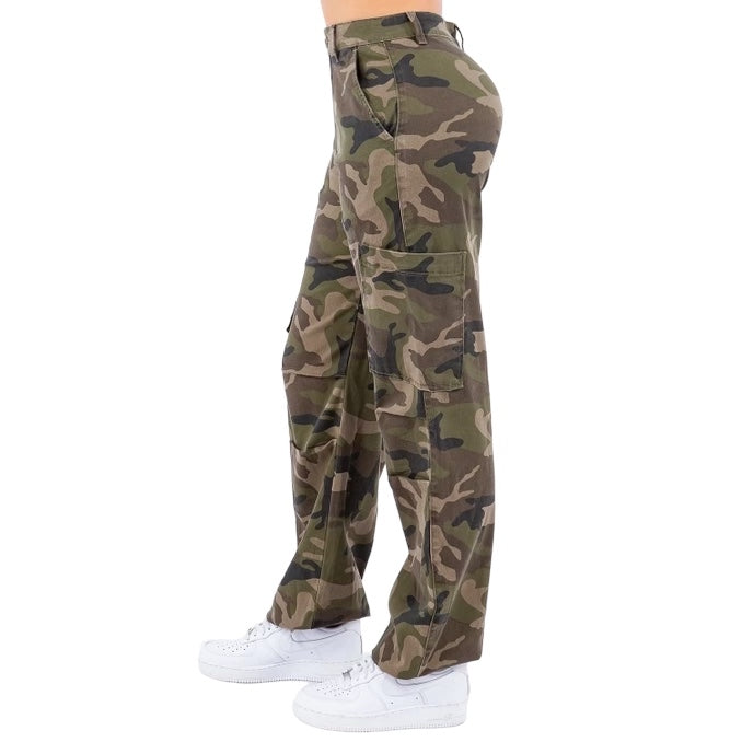a woman in camouflage print pants and white sneakers
