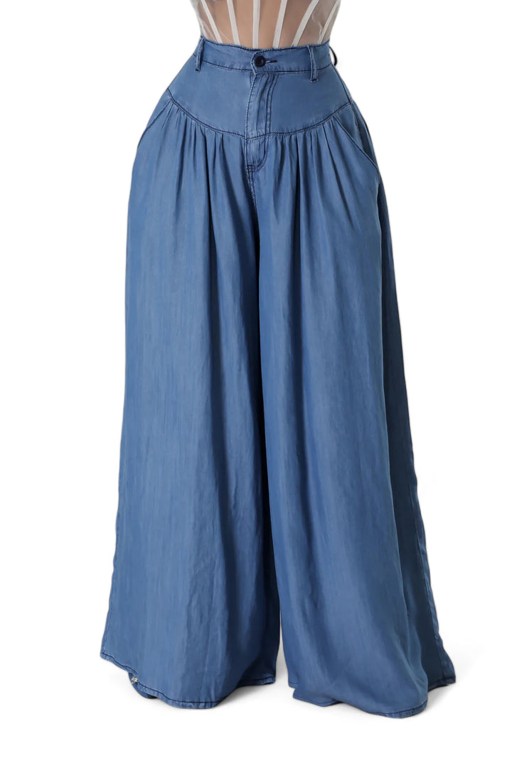 a woman is wearing blue pants and a sheer top