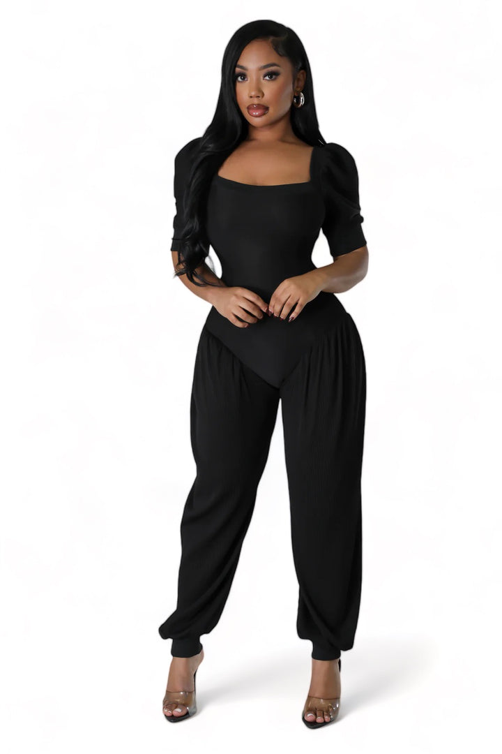 a woman in a black jumpsuit posing for the camera