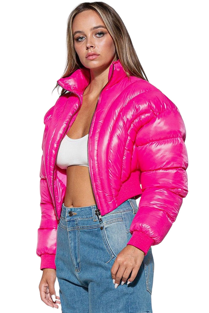 a woman wearing a bright pink jacket and jeans
