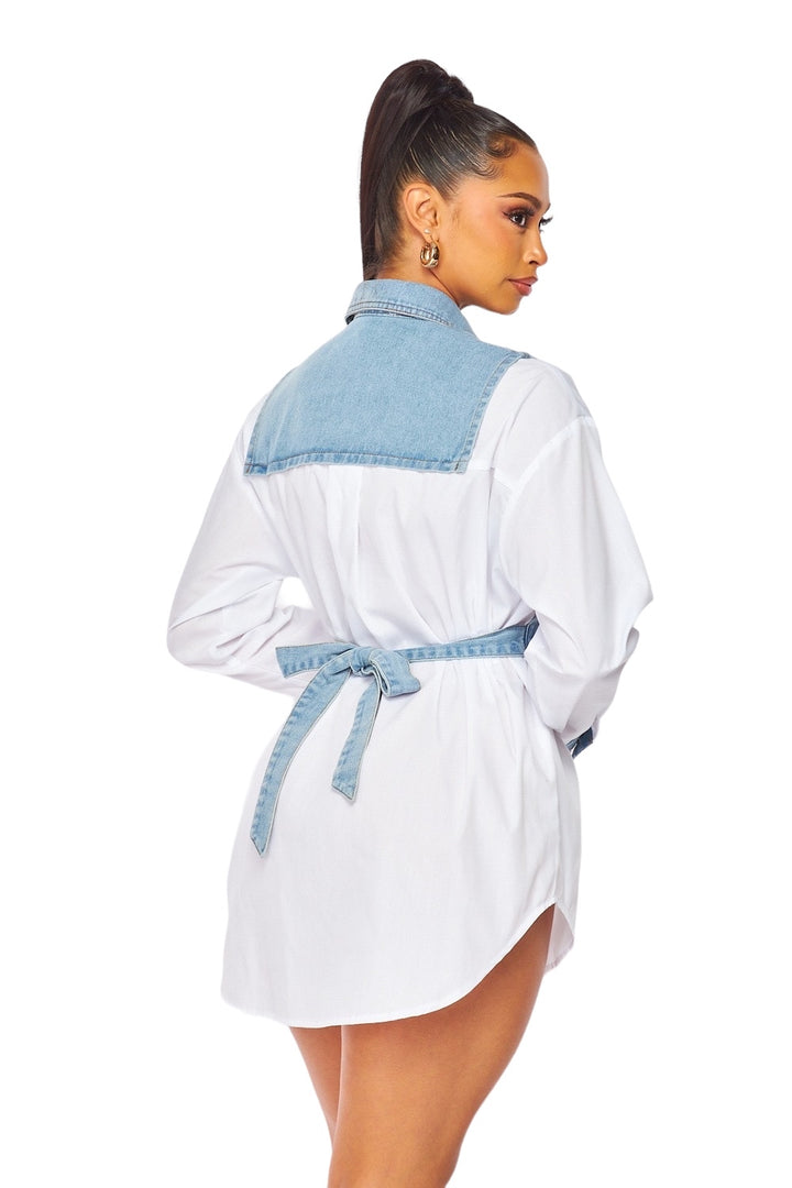 a woman in a white shirt dress with a blue sash around her waist