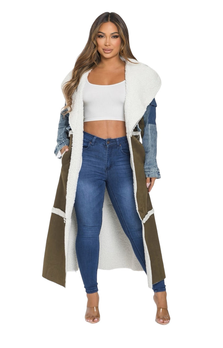 a woman wearing a long coat and jeans