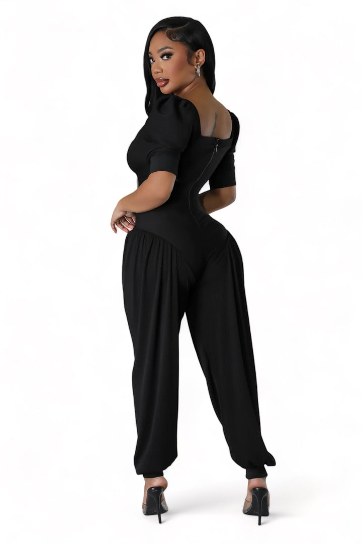 a woman in a black jumpsuit posing for the camera