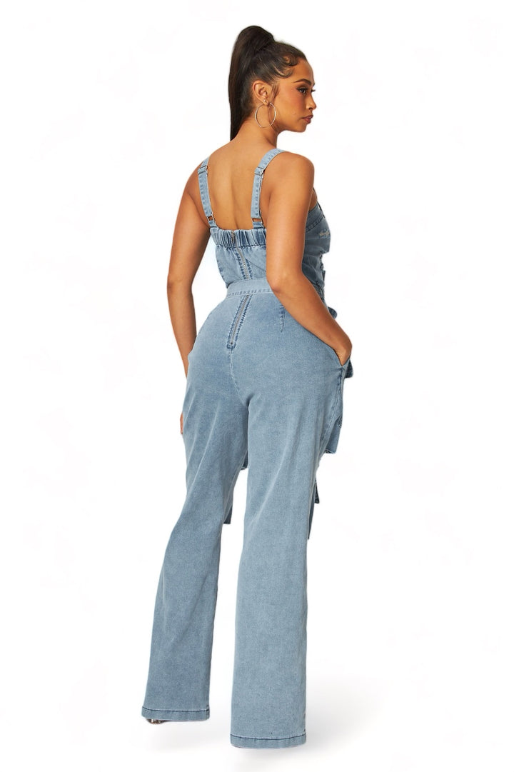 a woman in a denim jumpsuit with a back tie