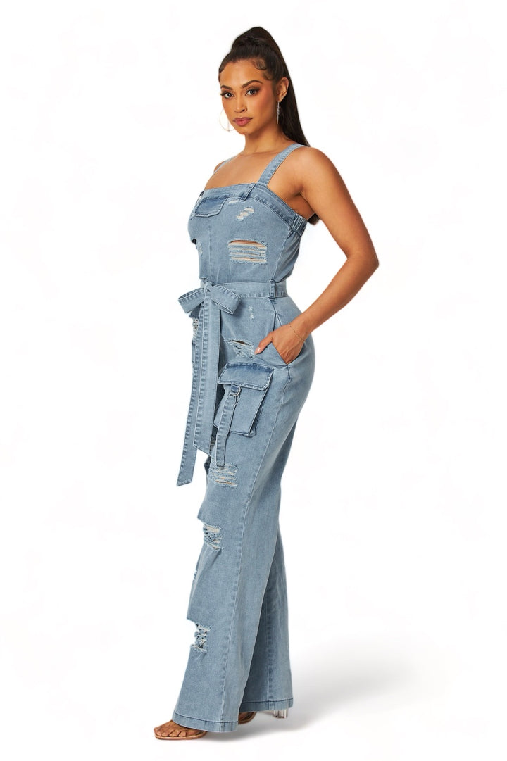 a woman wearing a denim jumpsuit with a tie around the waist
