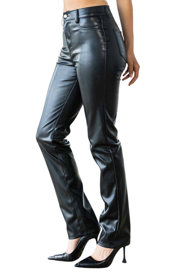 a woman wearing black leather pants and heels