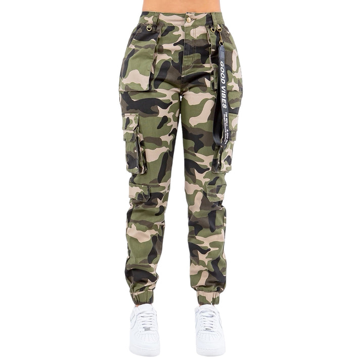 a woman wearing camouflage cargo pants and white sneakers