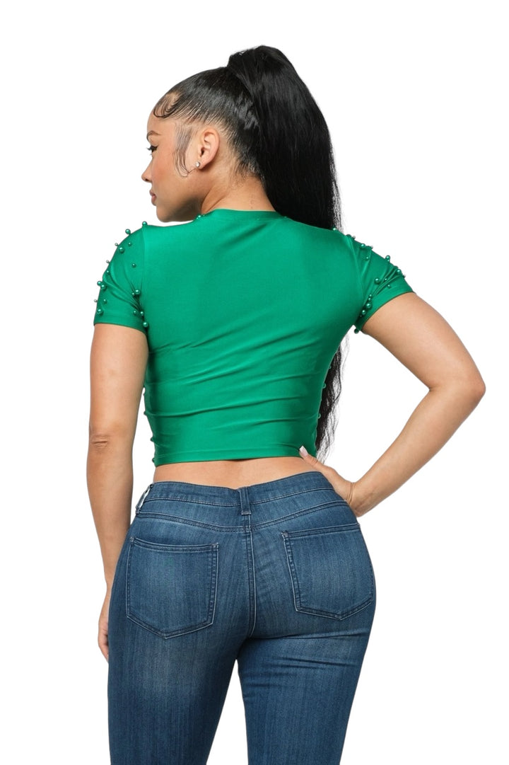 a woman wearing a green top and jeans