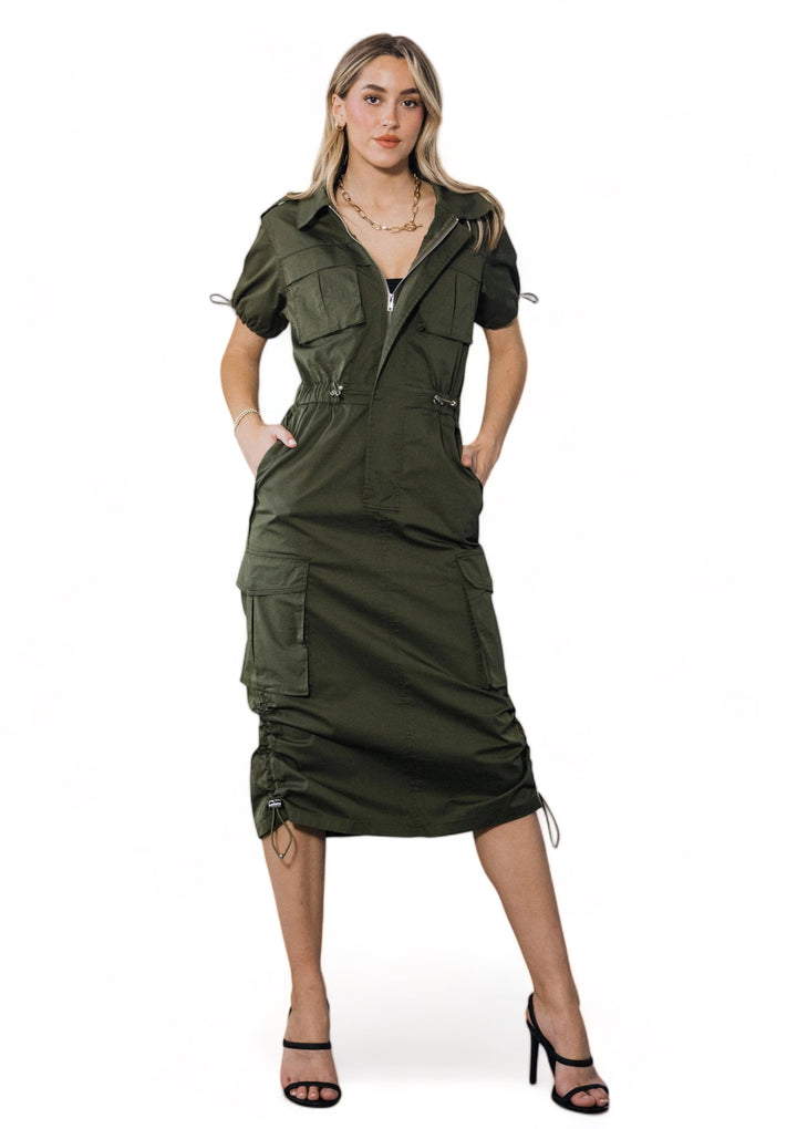 a woman wearing a green dress and black heels