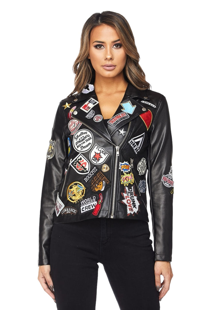 a woman wearing a black leather jacket with patches on it