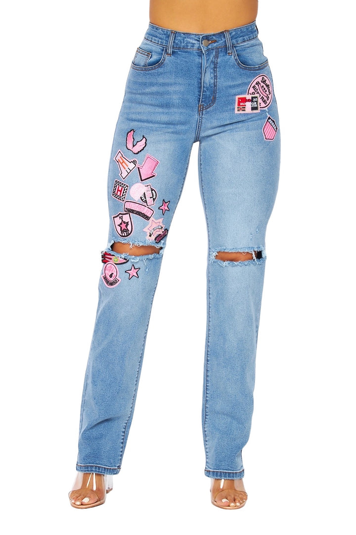 a woman wearing a pair of jeans with patches on it