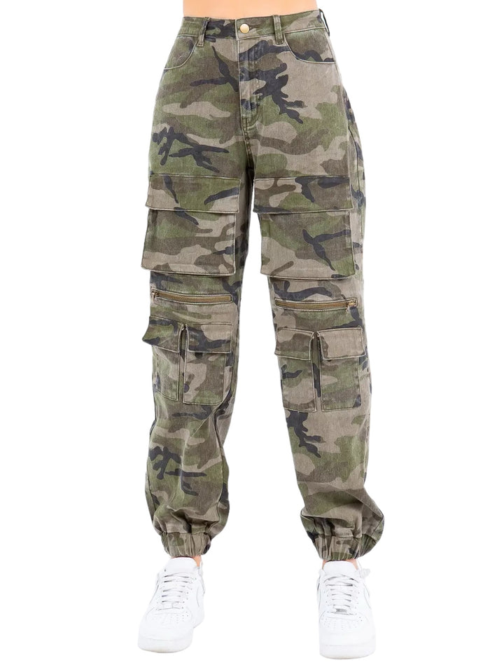a woman wearing camouflage cargo pants and white sneakers