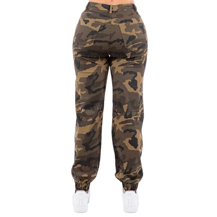 a woman in camouflage print pants and white sneakers