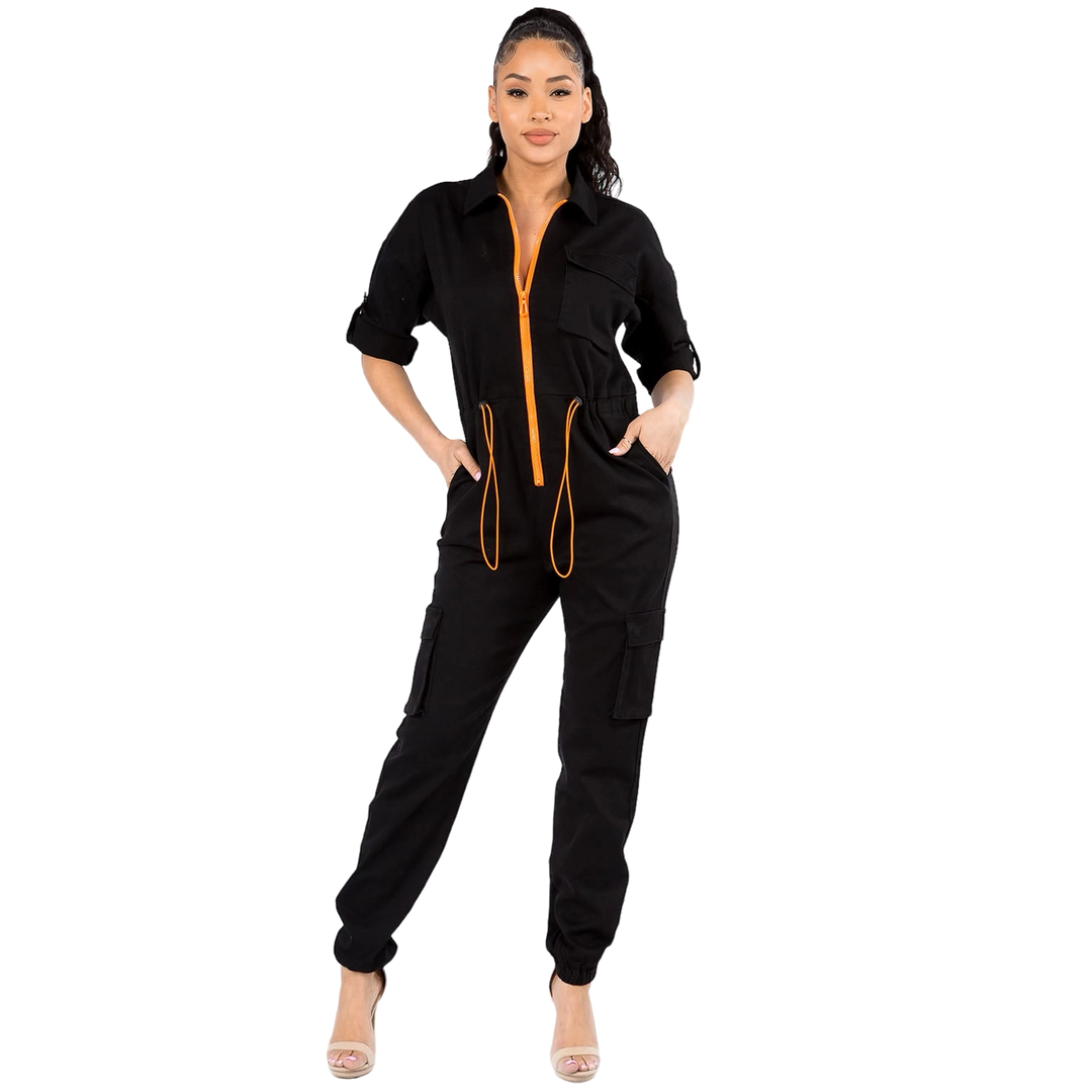 a woman wearing a black jumpsuit with an orange zipper
