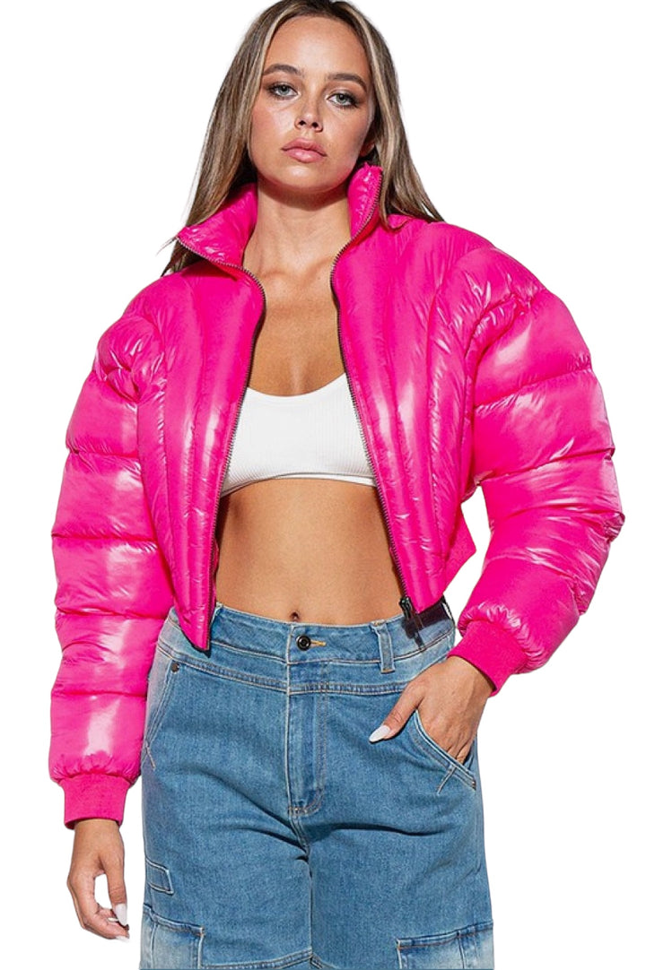 a woman wearing a pink jacket and jeans