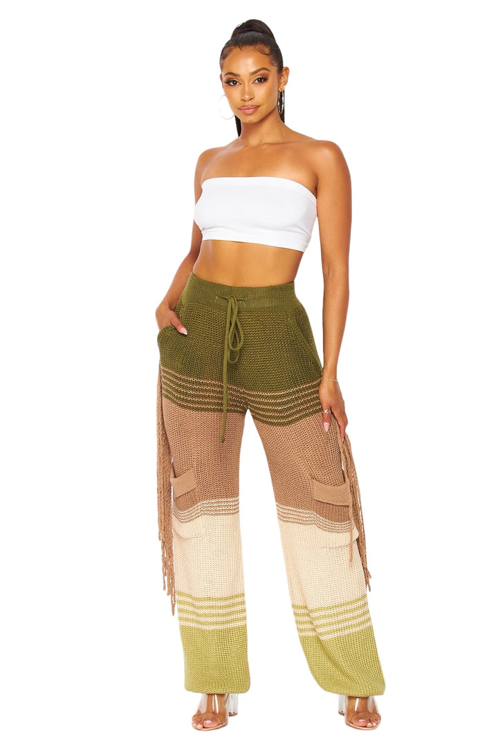 a woman in a white top and green pants