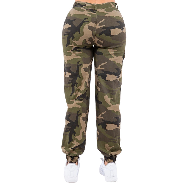 a woman wearing camouflage print pants and white sneakers