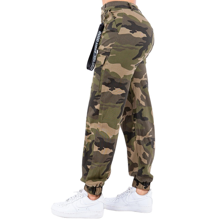 a woman wearing camouflage pants and white sneakers