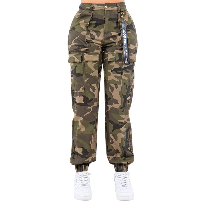a woman wearing camouflage pants and white sneakers