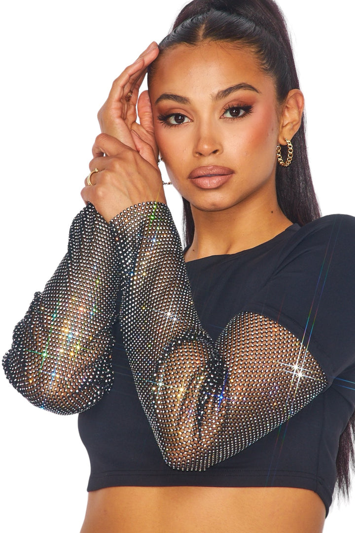 a woman wearing a black top with a mesh sleeve