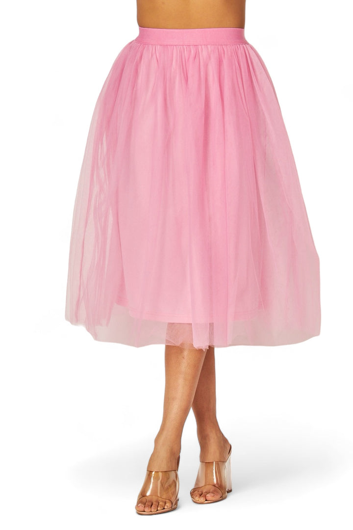 a woman wearing a pink skirt and sandals