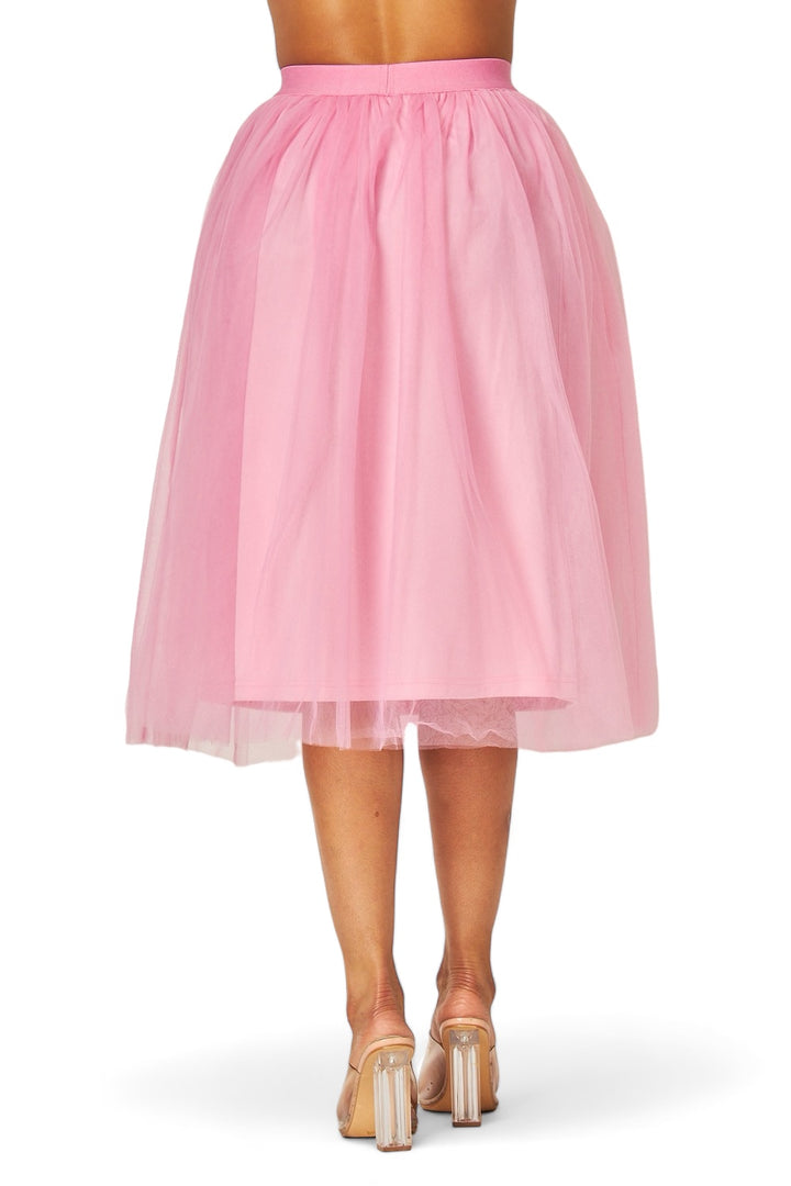 a woman wearing a pink skirt and high heels