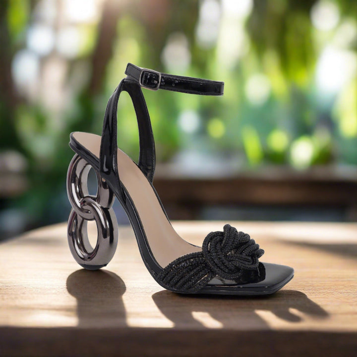 a pair of black high heeled shoes sitting on top of a wooden table