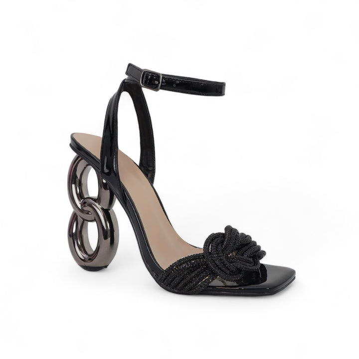 a black high heel sandal with a knot at the ankle