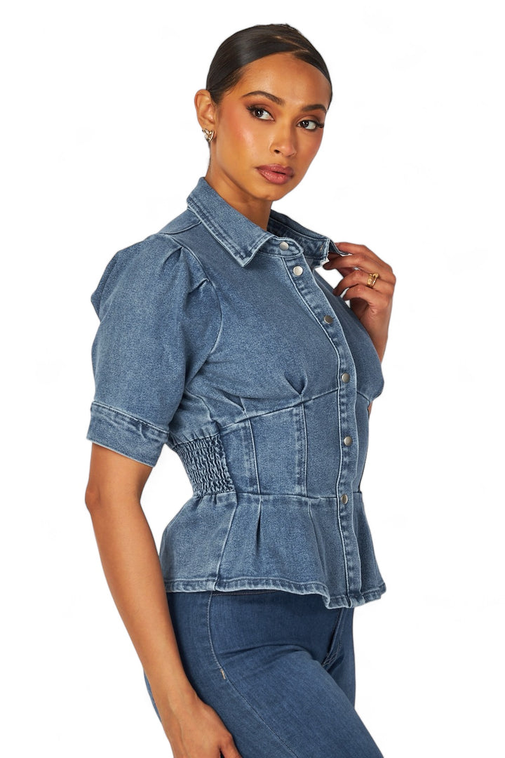 a woman wearing a denim shirt and jeans