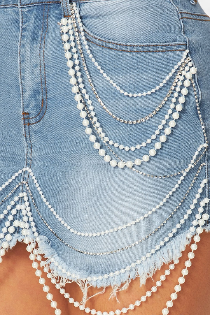 a close up of a person wearing a skirt with chains on it