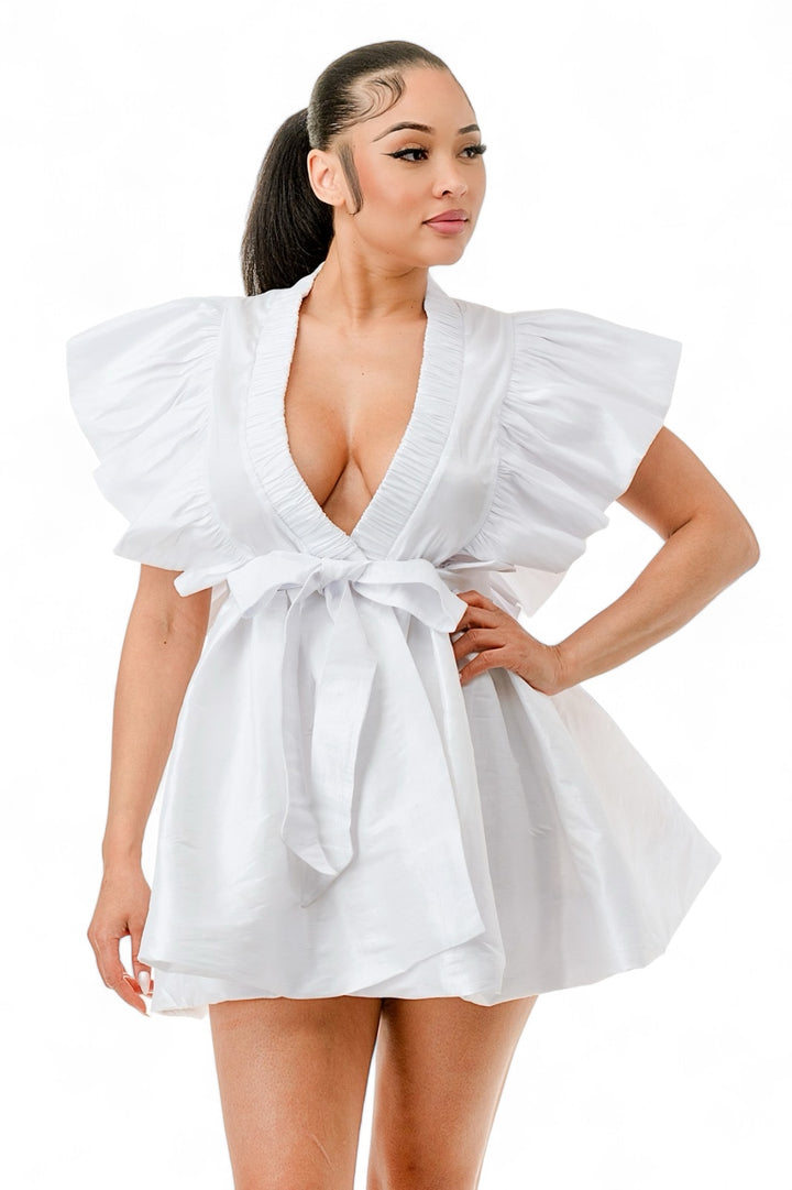 a woman in a white dress posing for a picture