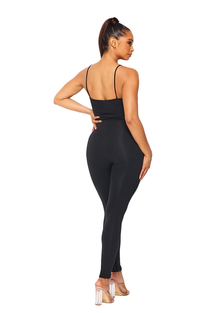 a woman wearing a black jumpsuit and heels
