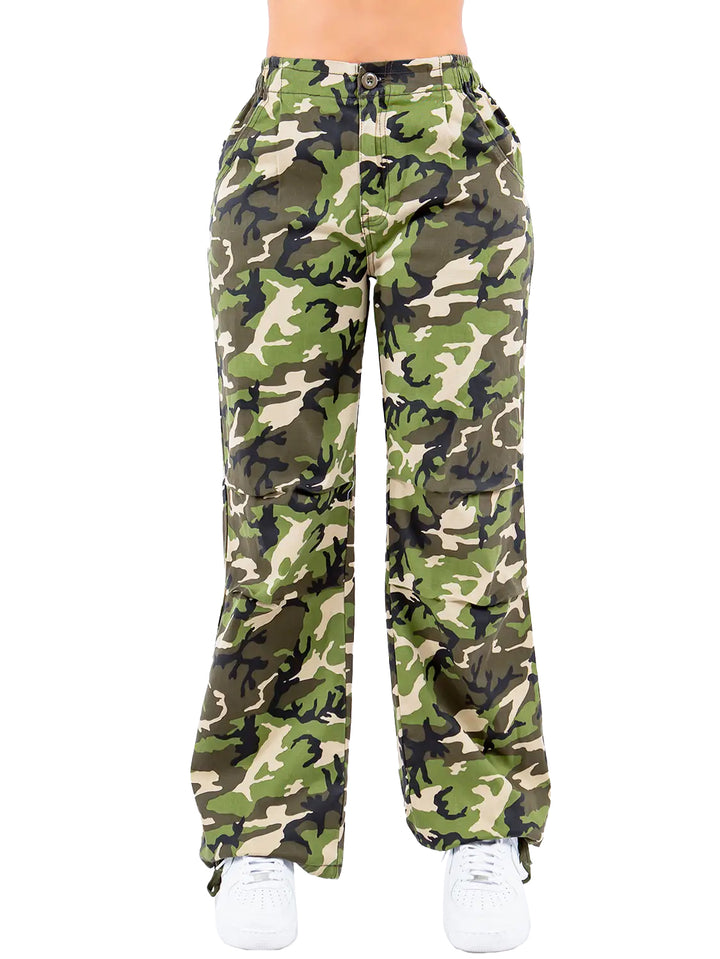 a woman wearing camouflage print pants and white sneakers
