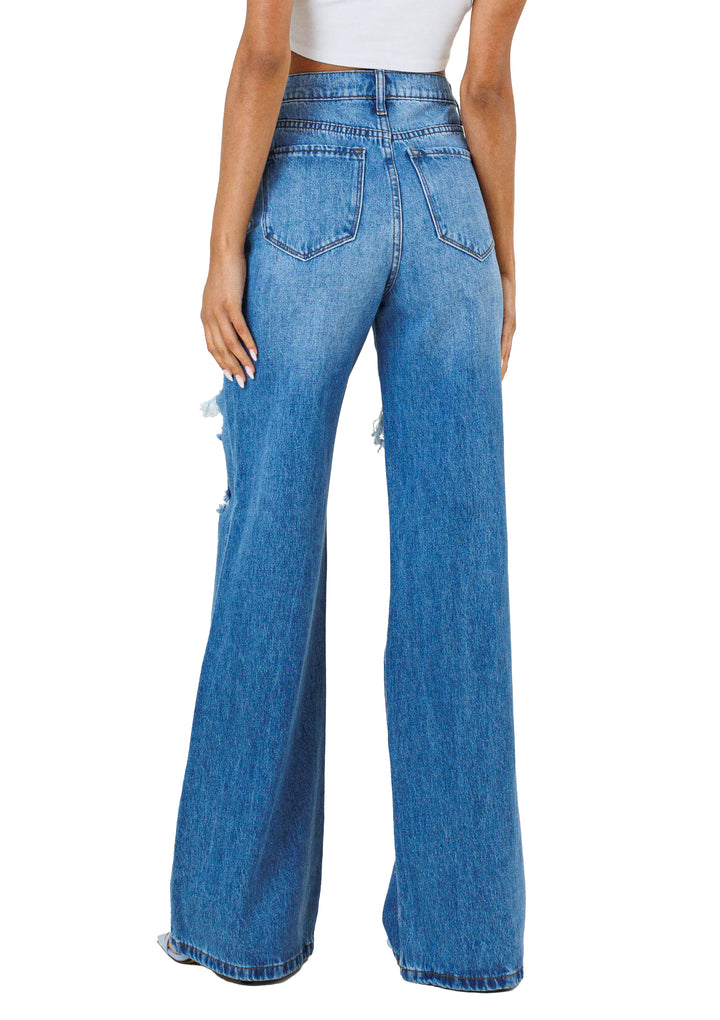 a woman wearing a white top and blue jeans