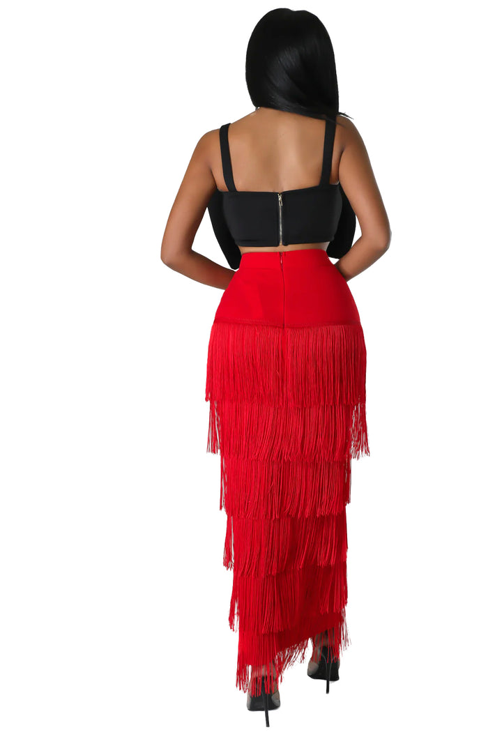 a woman wearing a red skirt and black top