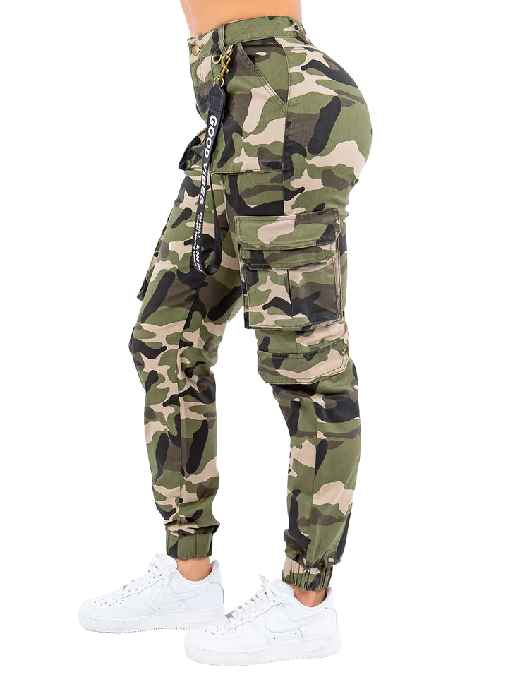 a woman in camouflage print pants and white sneakers
