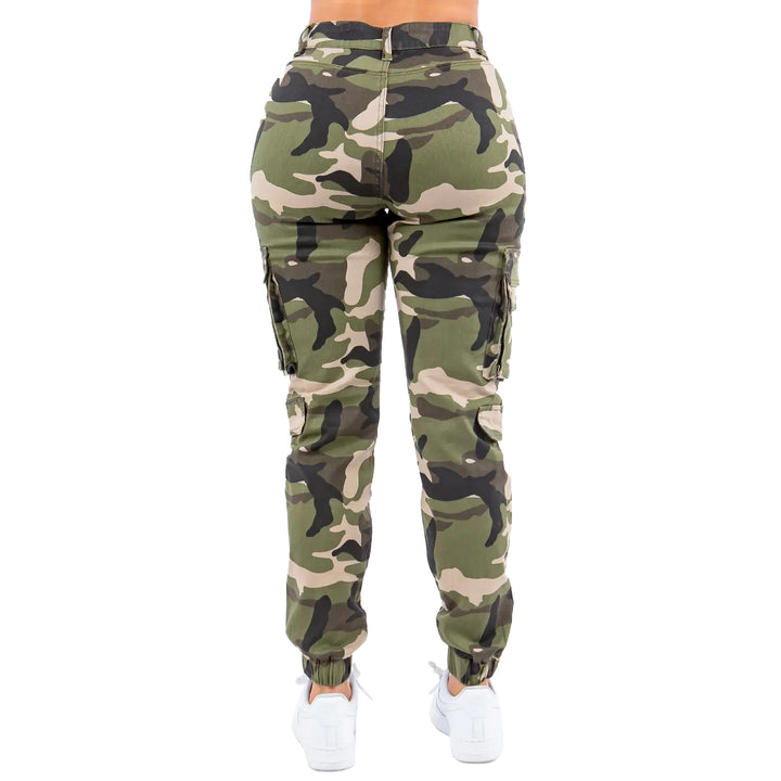 a woman wearing camouflage cargo pants and white sneakers