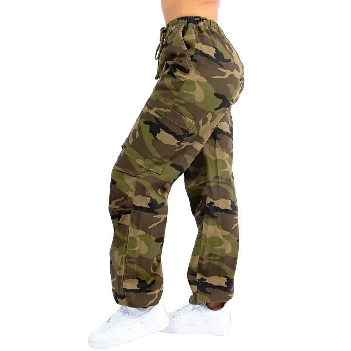a woman in camouflage print pants and white sneakers
