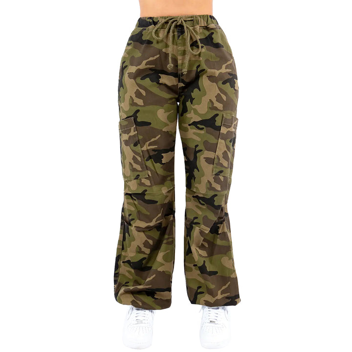 a woman wearing camouflage pants and white sneakers