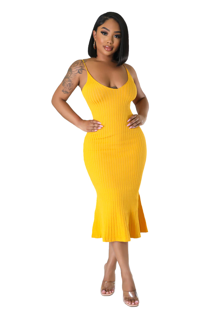 a woman in a yellow dress posing for a picture