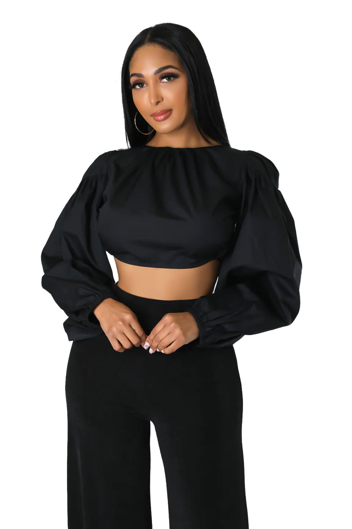 a woman wearing a crop top and wide legged pants