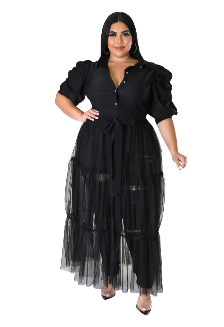 a woman wearing a black dress with sheer layers