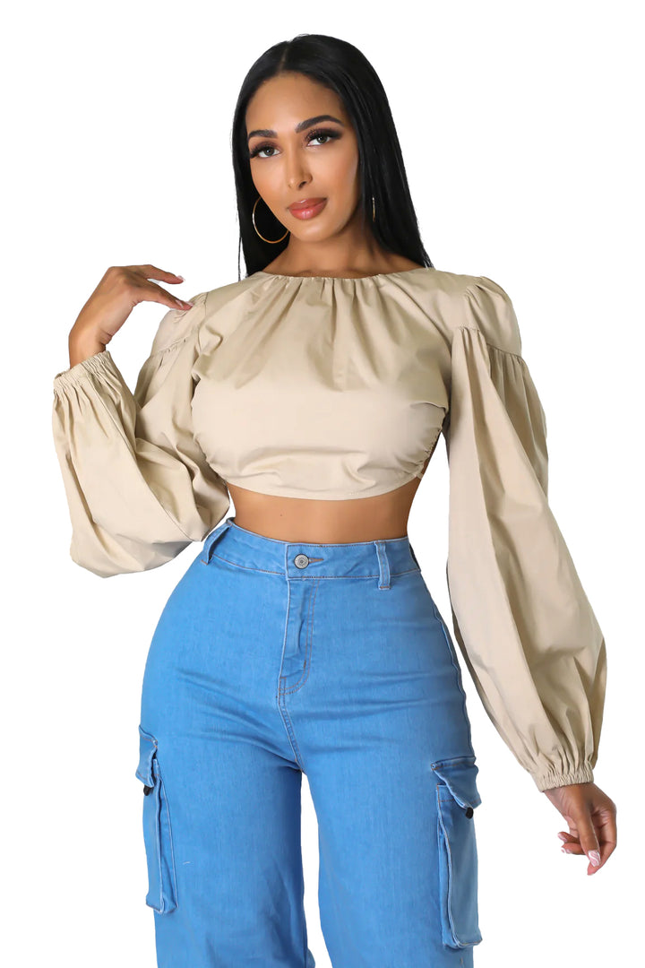 a woman wearing a cropped top and blue jeans