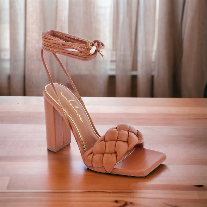 a woman's high heeled sandal on a wooden table