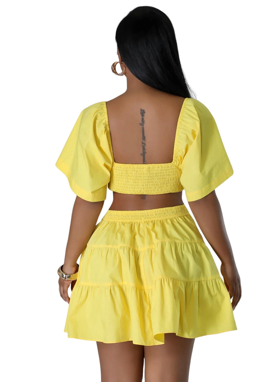 the back of a woman wearing a yellow dress