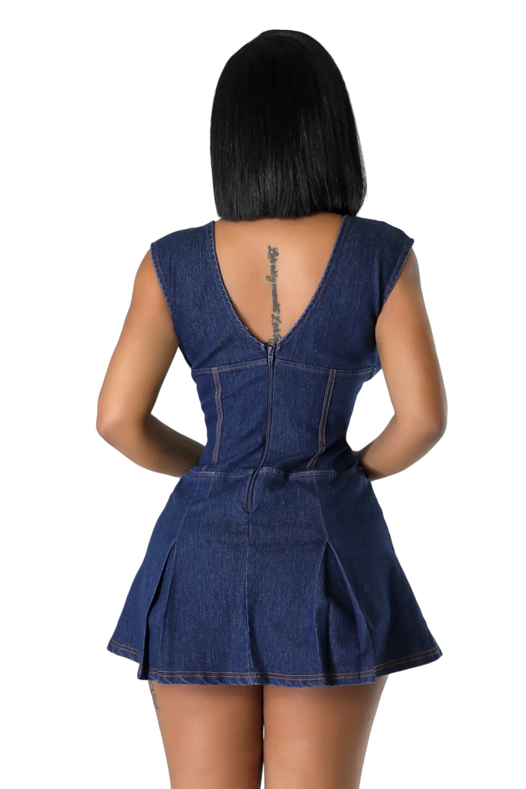 a woman wearing a denim dress with a back cut out