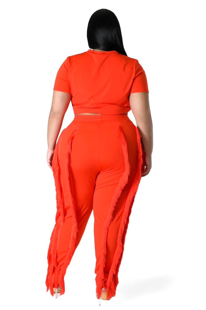 a woman in an orange jumpsuit and matching heels