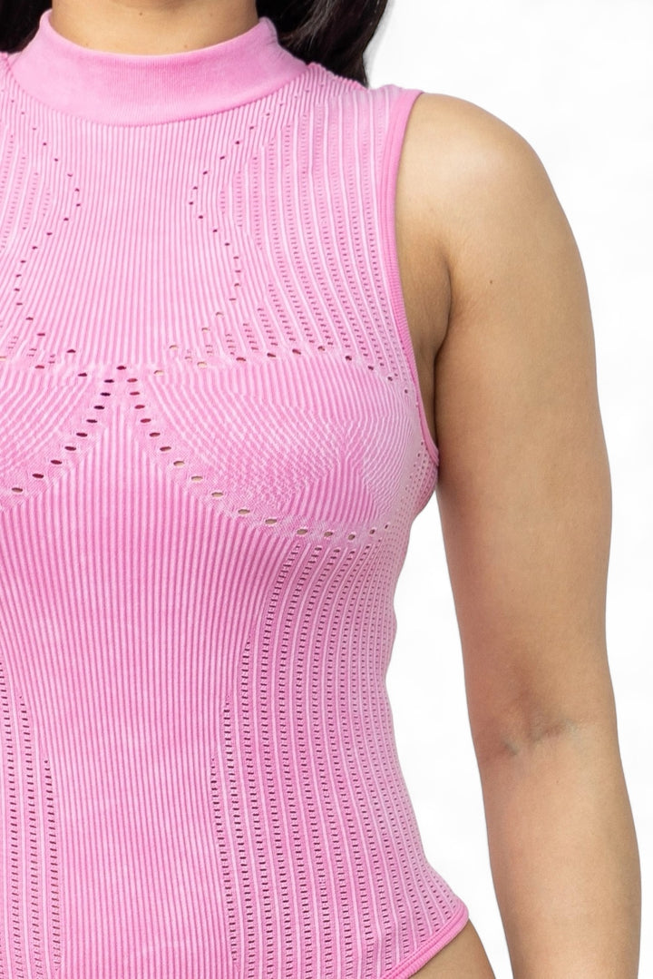 a woman wearing a pink top with holes on it