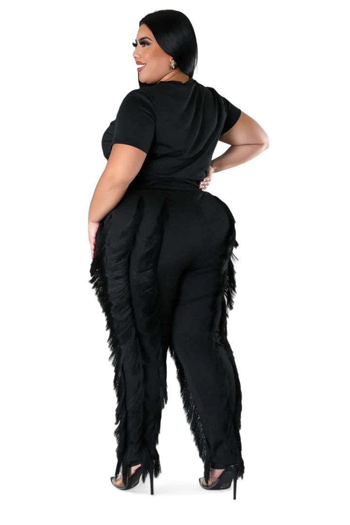 a woman wearing a black jumpsuit with feathers